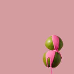 Pop art composition. Green apples with neon pink paint on pastel background. Spring concept. Copy space.