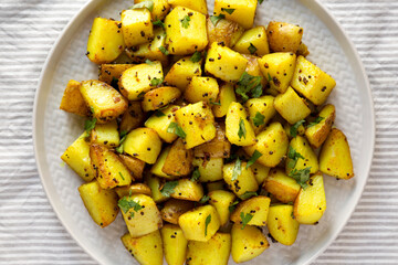 Homemade Roasted Potatoes with Mustard Seeds on a Plate, view from above. Flat lay, top view, overhead.