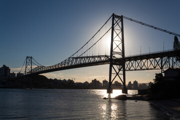 Pôr do sol e  raios solares ultrapassando a estrutura da Ponte Hercílio Luz , Santa Catarina, Brasil, florianopolis , Florianópolis