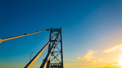 Pôr-do-sol e a   Torre e o sistema de barras de olhal da Ponte Hercílio Luz, ponte pênsil...