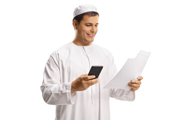 Young muslim man holding a paper and a mobile phone