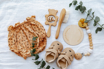 Newborn booties with empty card and wooden toys. Baby Background, top view, flat lay, copy space