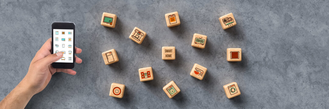 cubes with smart home icons and smartphone on cork background