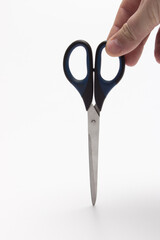 Scissors in the hands of a man. Stationery scissors in hand isolated on a white background.