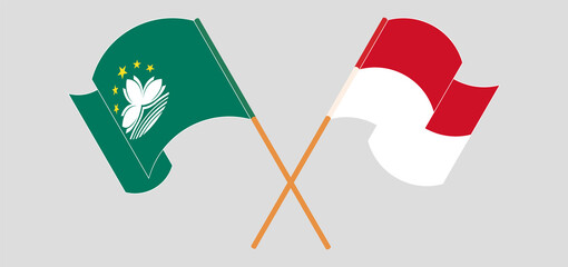 Crossed and waving flags of Macau and Indonesia
