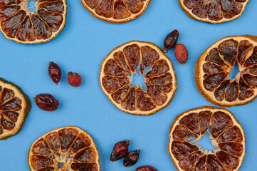 dried oranges and rose hips on a blue background