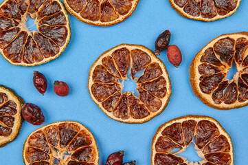 dried oranges and rose hips on a blue background