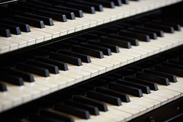 Simple triple pipe organ instrument keyboard. Three organ keyboards stack, keys closeup. .Detail of pipe organ console three hand-keyboards