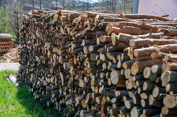 Fuel for stove heating. Country life. Wooden firewood stacked wall. Firewood stacked in several rows