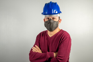 middle aged man with construction helmet and protective mask looking