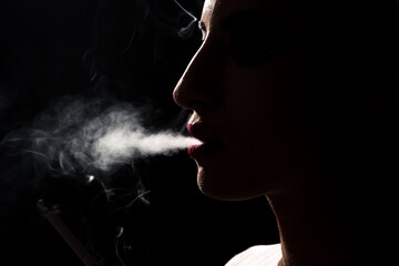 A smoking girl in a smoke close up