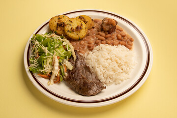 typical Brazilian food dish with rice, beans, meat, green salad and potatoes