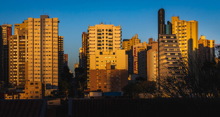 Buildings in a city being illuminated by the light of the setting sun. View of the city of Londrina...