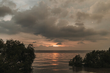 Fototapeta na wymiar Calm sunset ocean with stormy cloud in the sky.