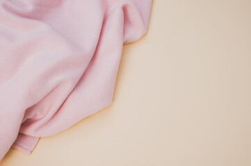 Closeup of a pink piece of cloth on a soft orange background with copy space