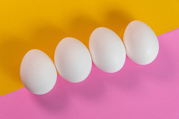 Eggs on the yellow and pink background
