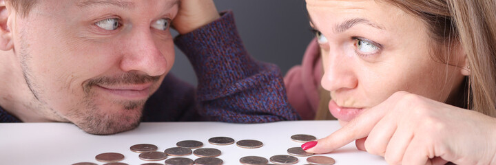 Man and woman look at coins in frustration