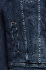 Fototapeta premium Close-up denim jacket pocket. Denim jacket background. Blue jeans texture for background. Close-up blue denim texture. Texture of blue jeans as background, close up.