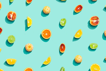 Colorful fruit pattern from fresh citrus, lemon, red orange, tangerine and lime on blue background. Summer food.