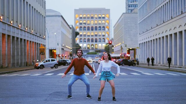synchronized modern dance steps performed by a young couple on the street