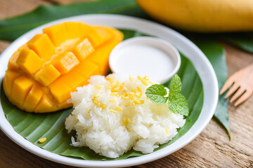 Ripe mango rice cooked with coconut milk, Asian Thai dessert tropical sweet mango peel and sliced...