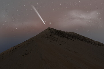 White comet over the sand mountain in morning sky