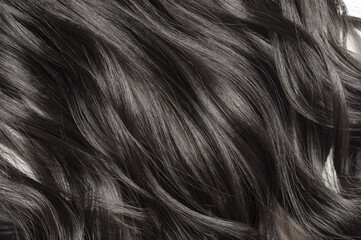 closeup of single piece of clip in wavy black synthetic hair extensions