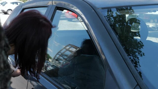 quarrels during the lockdown -young woman wakes her husband sleeping in the car 