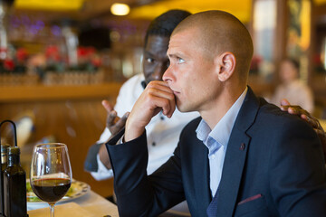 Two men discussing problems at table in a restaurant