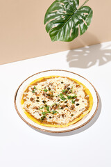 Modern minimal photo of oven pizza with tuna and capers, great design for any purposes. Pizza poster. White table with beige wall in sunshine with palm leaf shadow. Pizza summer day concept.