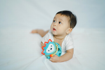 asian baby girl in 6 month with toy on floor fabric with white background for learning and development concept