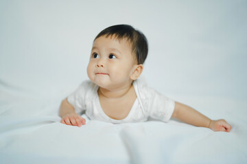Fototapeta premium asian baby girl in 6 month on floor fabric with white background for learning and development concept