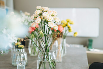 The bouquet of peach roses in glass vase on table. Florist working place