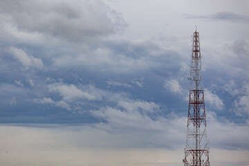 One red and white telephone pole behind the sky.