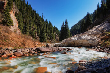 A river in the mountains of Kyrgyzstan in the Semenovsky gorge, high mountains, stormy streams of...