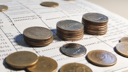 Growing money saving and investment concept, double exposure of coins stack on bank account book.