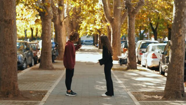 quarrel between friends - two girls argue in the street and one slaps the other