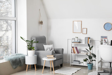 Shelf unit with books and armchair in interior of room