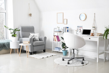 Comfortable workplace and armchair in interior of light room