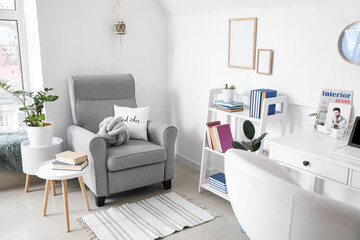Fototapeta na wymiar Shelf unit with books and armchair in interior of room