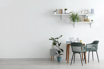 Shelves with books and dining table in interior of room