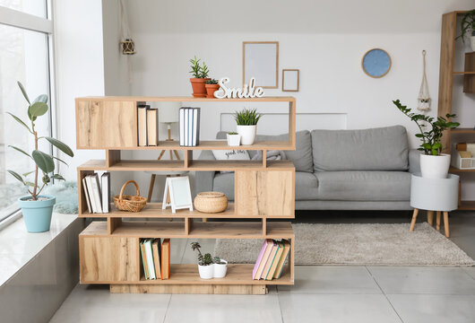 Shelf unit with books and sofa in interior of room