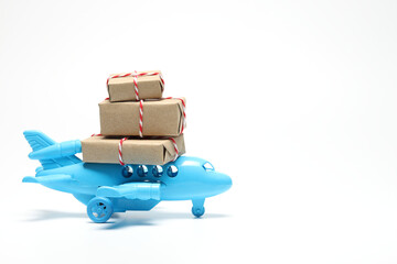 Parcel box on toy airplane in white background with copy space. Air cargo and parcels...