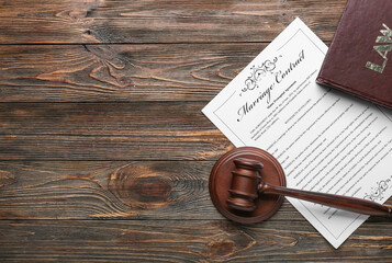 Marriage contract with judge's gavel and book on wooden background