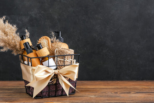 Gift basket with cosmetic products on dark wooden background