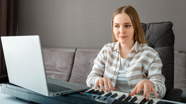 Woman Learns To Play Piano Online Using Laptop At Home Interior. Woman Plays Instrument On Synthesizer Piano During Online Lesson With Teacher. Online Concert Stream Performer. Long Web Banner