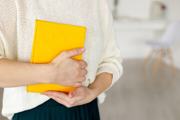 woman businessman holding a yellow notepad. Business planning and tasks for the day or week. Female in business