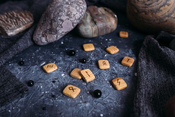 Fortune telling on wooden runes among stones. Gloomy and mysterious witch table.