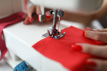 Close-up of dressmaker lady working on sewing machine
