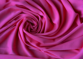 Smooth elegant pink silk or satin luxury cloth texture can be used as abstract background. Crumpled fabric Twisted at the side
